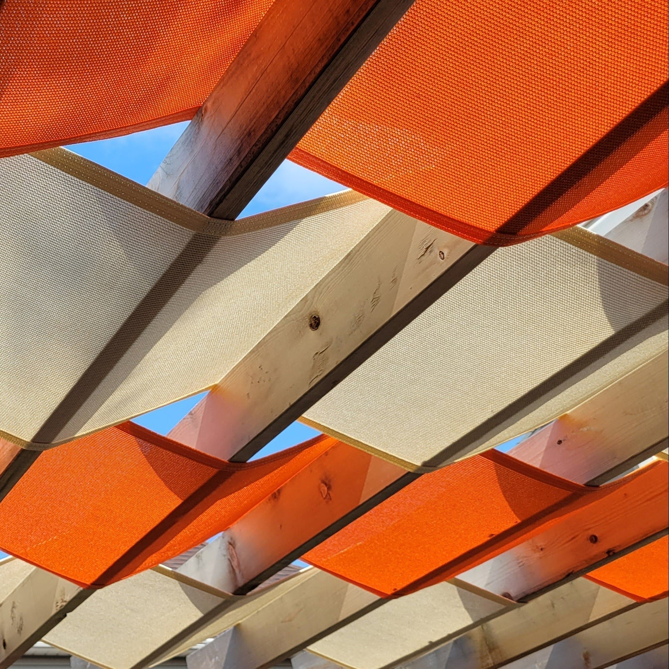 close up image of a orange and beige pergola shade showcasing how shade helps energy consumption