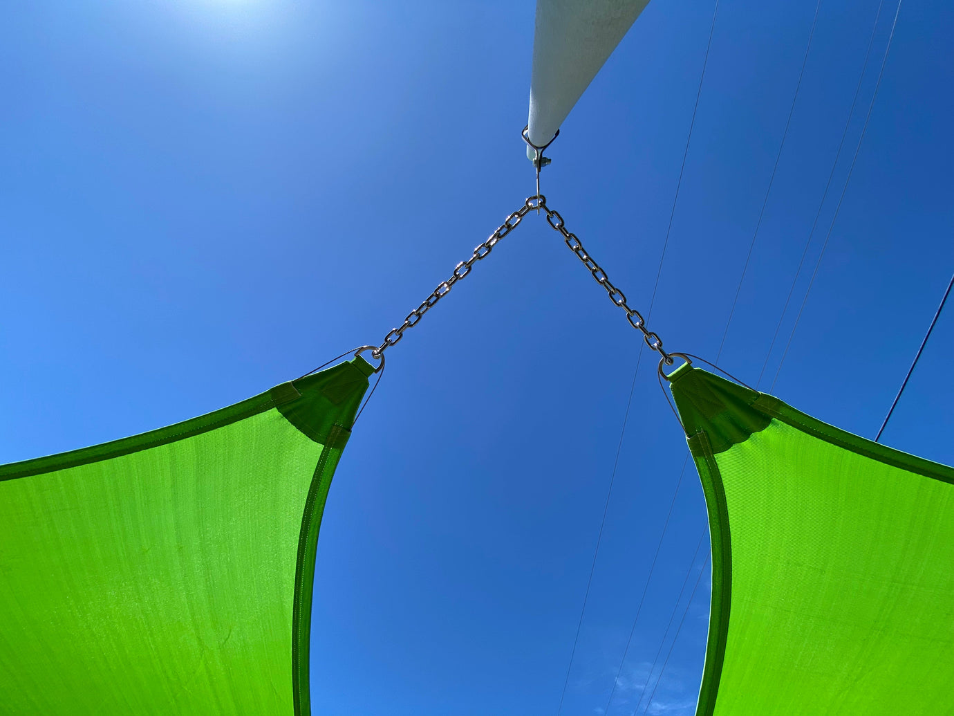 close up view of three green shade sails attached representing pickleball court shade structure