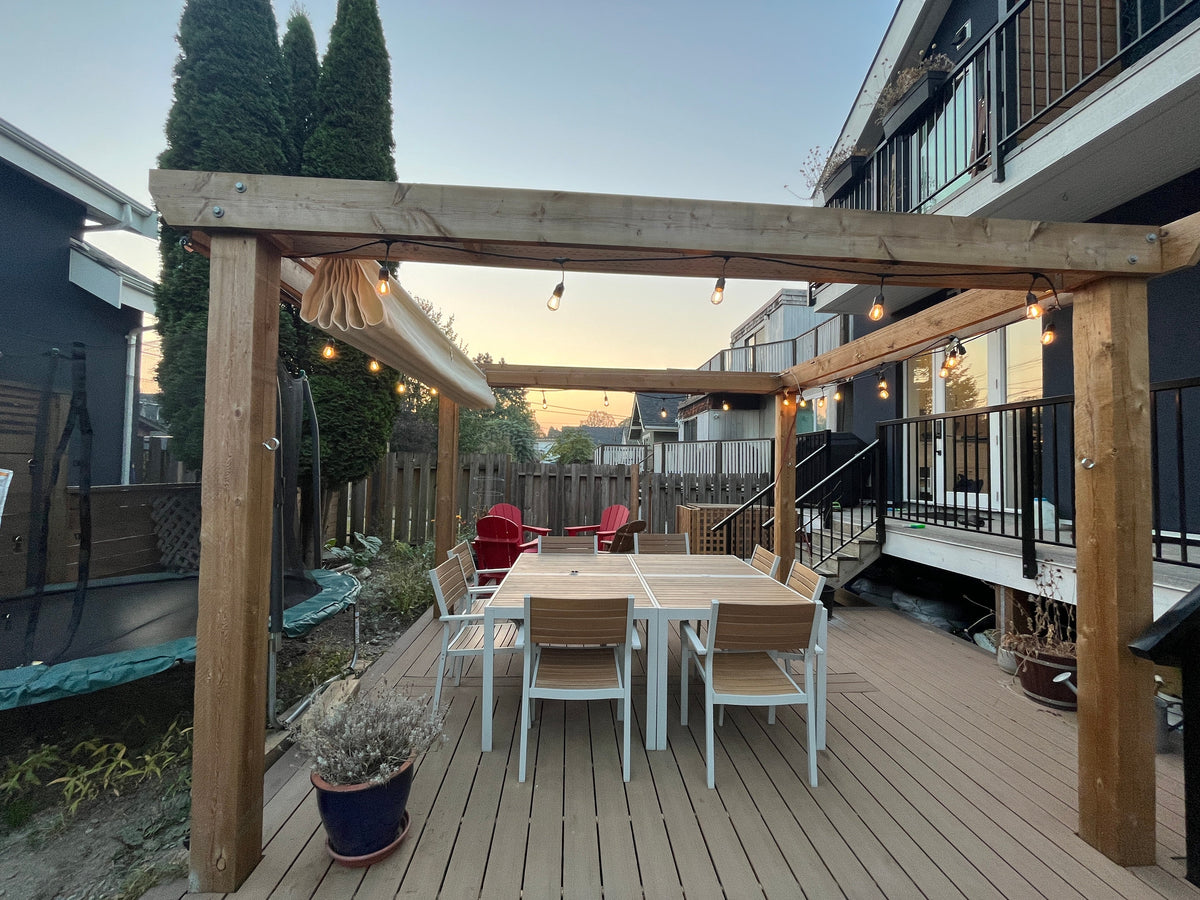 backyard pergola on deck with white chairs and table providing outdoor privacy solutions Canada.